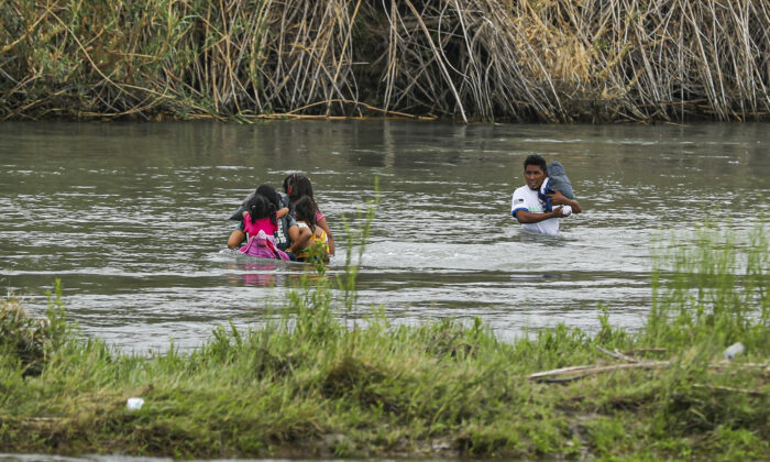 Un grupo de hondureños cruza el Río Grande hacia Eagle Pass, Texas, desde Piedras Negras, México, el 21 de abril de 2022. (Charlotte Cuthbertson/The Epoch Times)
