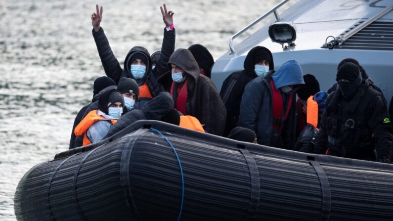 Inmigrantes ilegales reaccionan a bordo de la embarcación de la Fuerza Fronteriza del Reino Unido HMC Speedwell después de ser recogidos en el mar, mientras son llevados a la Marina en Dover, sureste de Inglaterra, el 21 de diciembre de 2021. (Ben Stansall/AFP vía Getty Images)
