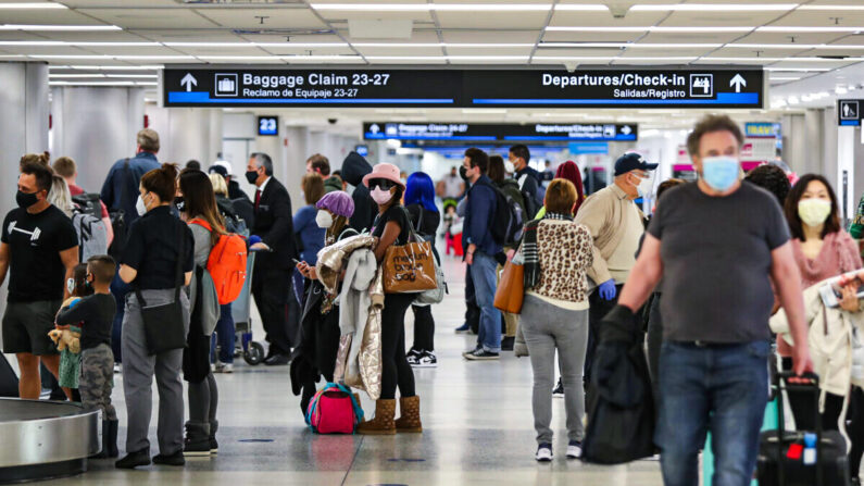 La gente recoge su equipaje tras llegar al Aeropuerto Internacional de Miami en un avión procedente de Nueva York en Miami, Florida, el 1 de febrero de 2021. (Joe Raedle/Getty Images)
