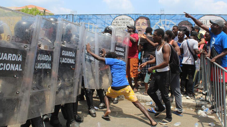 Migrantes centroamericanos se enfrentan con policías de la Guardia Nacional el 6 de abril de 2022, en Tapachula (México). EFE/ Juan Manuel Blanco