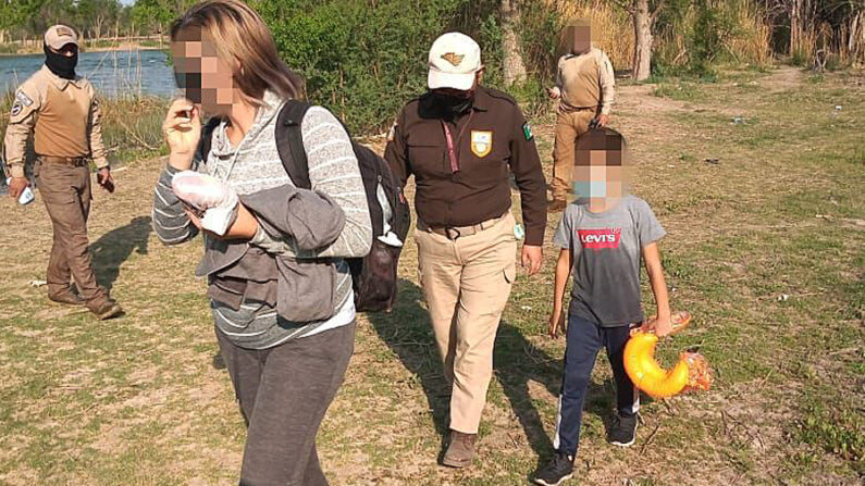 Fotografía cedida el 15 de abril de 2022 por el Instituto Nacional de Migración (INM), donde se observa el rescate de una madre acompañada de su hijo en las inmediaciones del Río Bravo, en el estado de Coahuila (México). EFE/ Instituto Nacional De Migración