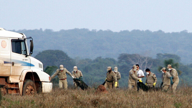 En una foto de archivo bomberos del Departamento de Bomberos de Mato Grosso llevan los cuerpos de las víctimas de un accidente de avión en Mato Grosso, a 950 km al norte de Brasilia (Brasil), el 3 de octubre de 2006. (Evaristo Sa/AFP vía Getty Images)