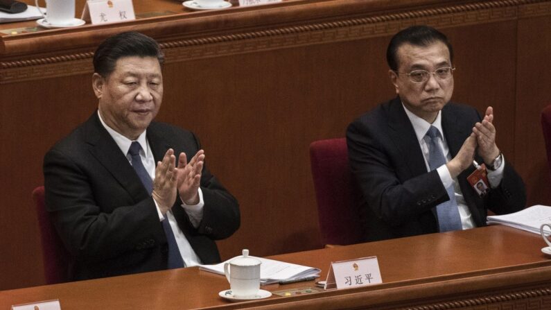 El líder chino Xi Jinping (izq.), y el primer ministro Li Keqiang (der.) aplauden durante la tercera sesión plenaria de la Asamblea Popular Nacional en El Gran Salón del Pueblo, el 12 de marzo de 2019, en Beijing, China. (Kevin Frayer/Getty Images)
