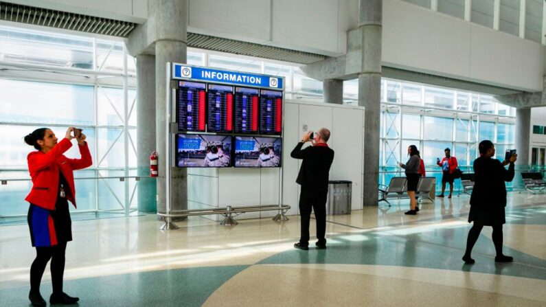 Trabajadores usan sus teléfonos para tomar fotos de un tablero de información que muestra vuelos cancelados en la sala de salidas del Aeropuerto Internacional de Fort Lauderdale-Hollywood, en Fort Lauderdale, Florida, el 2 de septiembre de 2019. (EVA MARIE UZCATEGUI/AFP vía Getty Images)