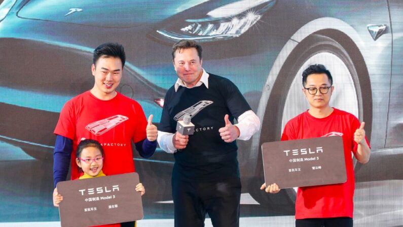Elon Musk (C), director ejecutivo de Tesla, posa para las fotos con los compradores durante la ceremonia de entrega del Model 3 fabricado en China por Tesla en Shanghái. Musk presentó el 7 de enero de 2020 el primer lote de coches fabricados en China a los compradores. (STR/AFP vía Getty Images)
