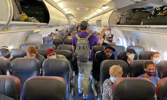 Pasajeros, casi todos con mascarillas, suben a un vuelo de American Airlines con destino a Charlotte, el 3 de mayo de 2020, en Nueva York. (Eleonore Sens/AFP vía Getty Images)