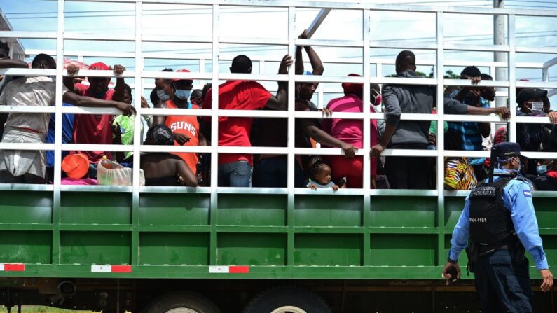 Migrantes que se dirigen en una caravana a la frontera con Guatemala son detenidos por la policía mientras viajan a bordo de un camión en Cerro de Hula, 10 km al sur de Tegucigalpa (Honduras), el 3 de junio de 2020. (Orlando Sierra/AFP vía Getty Images)