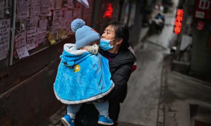 Una mujer con un bebé en brazos en Wuhan, provincia central de Hubei, en China, el 22 de enero de 2021. (Hector Retamal/AFP vía Getty Images)
