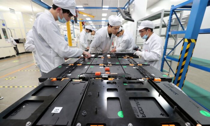 Trabajadores de una fábrica de Xinwangda Electric Vehicle Battery Co. Ltd, que fabrica baterías de litio para automóviles eléctricos y otros usos, en Nanjing, en la provincia oriental china de Jiangsu, el 12 de marzo de 2021. (STR/AFP vía Getty Images)
