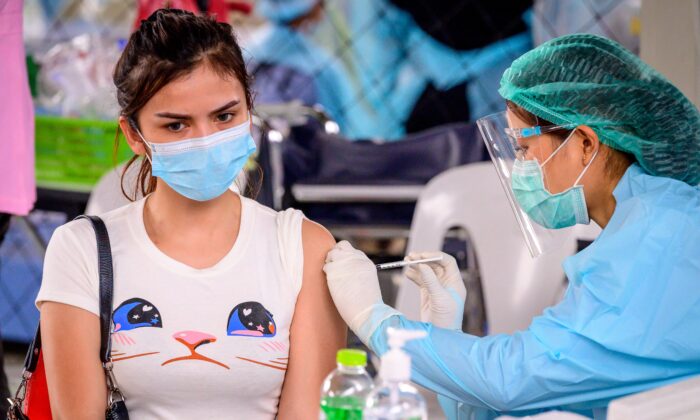 Un trabajador de la salud administra la vacuna CoronaVac, desarrollada por la empresa china Sinovac, a una mujer de un grupo en riesgo en el campo deportivo Saeng Thip en Bangkok, Tailandia, el 7 de abril de 2021. (Mladen Antonov/AFP a través de Getty Images)
