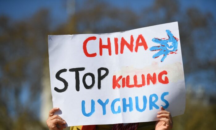 Un miembro de la comunidad uigur sostiene una pancarta mientras se une a una manifestación para pedir al parlamento británico que vote para reconocer la persecución de la minoría musulmana uigur de China como genocidio y crímenes de lesa humanidad en Londres, el 22 de abril de 2021. (Justin Tallis/AFP a través de Getty Images)