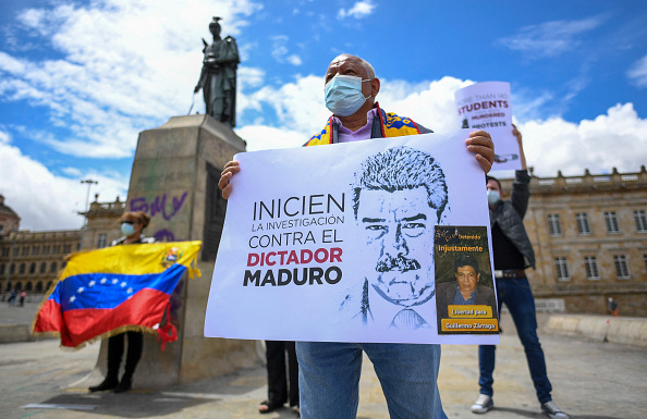 Políticos venezolanos en el exilio en Colombia protestan contra la visita del fiscal de la Corte Penal Internacional Karim Khan a Venezuela, en la plaza Bolívar de Bogotá, el 28 de octubre de 2021. (JUAN BARRETO/AFP vía Getty Images)