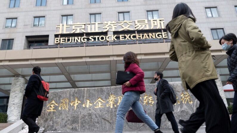 La gente pasa frente a la Bolsa de Valores de Beijing en su primer día de operaciones, en Beijing, China, el 15 de noviembre de 2021. (Wang Zhao/AFP a través de Getty Images)
