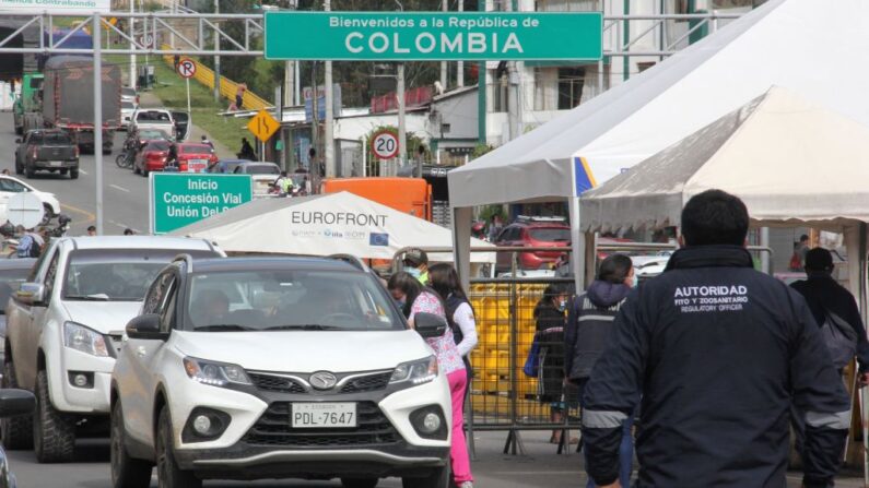 Vehículos cruzan la frontera desde Tulcán, Ecuador hacia Ipiales, Colombia, después de que los gobiernos de los dos países autorizaran la reapertura del puente internacional de Rumichaca en Ipiales, departamento de Narino, Colombia, el 17 de diciembre de 2021. (Leonardo Castro/AFP vía Getty Images)