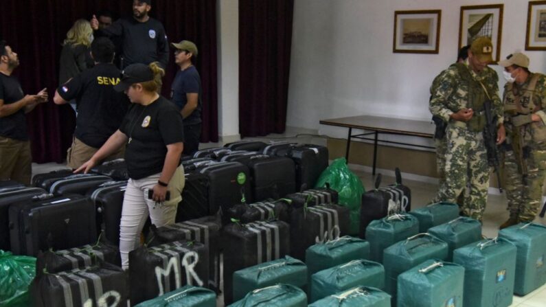 En una foto de archivo, agentes de la Unidad de Investigación de la Secretaría Nacional Antidrogas (SENAD) ordenan paquetes que contienen un total de 947 kilos de cocaína incautados durante un operativo en Eusevio Ayala, Departamento de Cordillera, a 65 km al norte de Asunción, en la sede de la SENAD en la capital paraguaya el 9 de enero de 2022. (Norberto Duarte/AFP vía Getty Images)