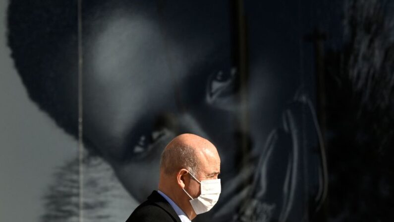 Un hombre con una mascarilla camina por una calle de Madrid el 27 de enero de 2022. (GABRIEL BOUYS/AFP vía Getty Images)