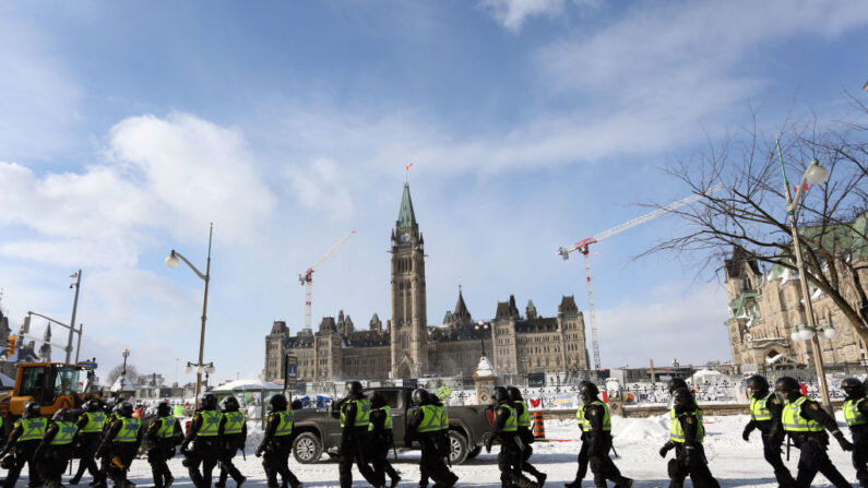 Un grupo de policías pasa por delante del Parlamento de Canadá después de que la calle fuera despejada de manifestantes en Ottawa, Ontario, Canadá, el 19 de febrero de 2022. (DAVE CHAN/AFP vía Getty Images)
