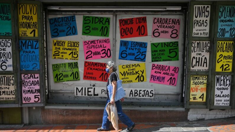 Los lugareños pasan por delante de un supermercado que muestra carteles con los precios de los productos en dólares estadounidenses, en Caracas (Venezuela), el 1 de abril de 2022. (Federico Parra/AFP vía Getty Images)