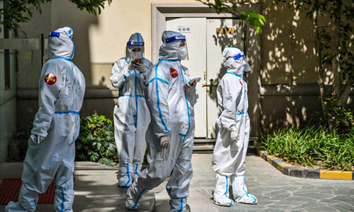 Trabajadores y voluntarios en un complejo donde se les hace pruebas para Covid-19 a los residentes durante la segunda etapa de un cierre pandémico, en el distrito de Jing'an, en Shanghái, el 4 de abril de 2022. (Héctor Retamal/AFP vía Getty Images)

