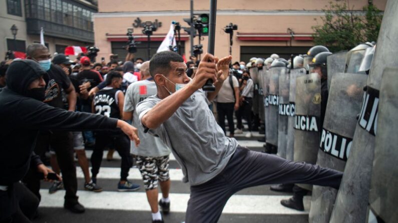 Un grupo de personas se enfrenta a la policía antidisturbios durante una protesta contra el gobierno del presidente de Perú, Pedro Castillo, en Lima el 5 de abril de 2022. (ERNESTO BENAVIDES/AFP vía Getty Images)