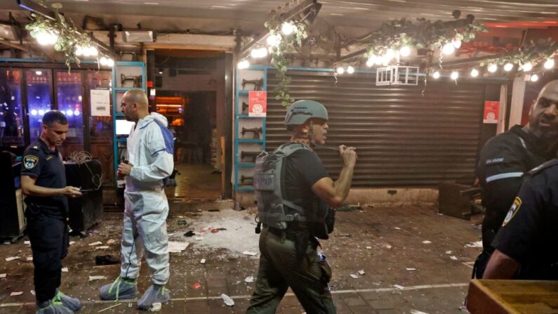 La policía y un experto forense llegan al lugar de los hechos tras un ataque a tiros en la calle Dizengoff, en el centro de la ciudad costera mediterránea israelí de Tel Aviv, el 7 de abril de 2022. (Jack Guez/AFP vía Getty Images)