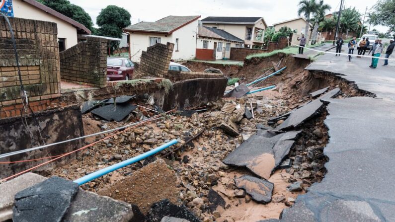 Vista general de una vivienda gravemente dañada y una grieta en la carretera tras las fuertes lluvias y vientos en Durban, el 12 de abril de 2022. (RAJESH JANTILAL/AFP vía Getty Images)