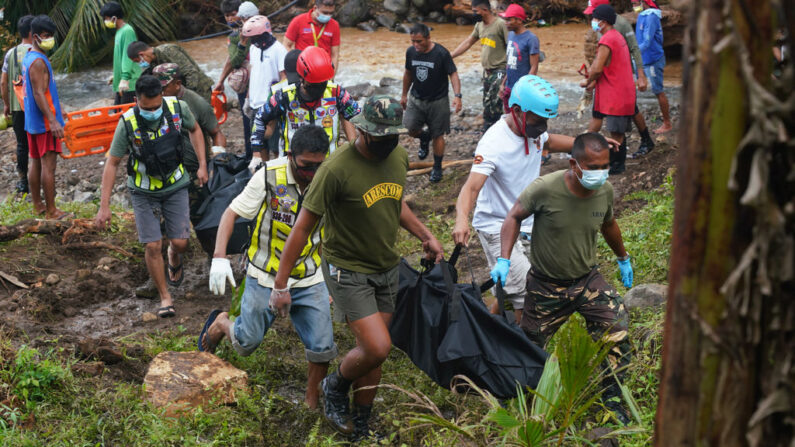 Los trabajadores de rescate llevan bolsas de cadáveres que contienen los cuerpos recuperados de las víctimas de un deslizamiento de tierra que azotó la aldea de Bunga en la ciudad de Baybay, provincia de Leyte (Filipinas), el 13 de abril de 2022, días después de las fuertes lluvias que inundaron la ciudad provocadas por la tormenta tropical Megi. (Bobbie Alota/AFP vía Getty Images)