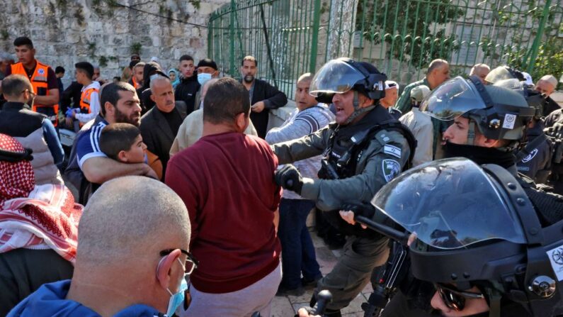 Las fuerzas de seguridad israelíes se enfrentan a hombres palestinos cuando intentan entrar en el recinto de la mezquita de Al-Aqsa para asistir a las oraciones del viernes, el 15 de abril de 2022. (Hazem Bader/AFP vía Getty Images)