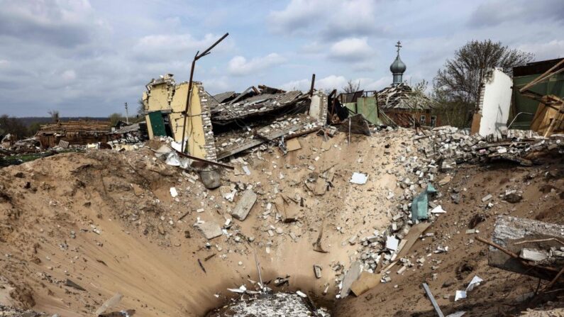 Un cráter y una casa destruida en el pueblo de Yatskivka, en el este de Ucrania, el 16 de abril de 2022. (RONALDO SCHEMIDT/AFP vía Getty Images)