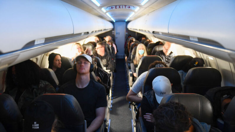 Los pasajeros de una aerolínea, algunos sin mascarillas tras el fin de las normas de transporte público de Covid-19, se sientan durante un vuelo de American Airlines operado por SkyWest Airlines desde el Aeropuerto Internacional de Los Ángeles (LAX) en California a Denver, Colorado, el 19 de abril de 2022.(PATRICK T. FALLON/AFP vía Getty Images)
