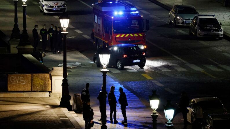 La policía investiga el lugar de un tiroteo en el que dos personas (i) fueron disparadas por la policía cuando conducían un coche (c) hacia los agentes en París (Francia) el 25 de abril de 2022. (Ludovic Marin / AFP vía Getty Images)