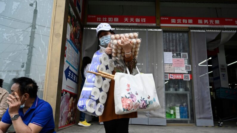 Una mujer sale de un supermercado tras comprar alimentos y provisiones para el hogar en Beijing el 25 de abril de 2022. (JADE GAO/AFP vía Getty Images)
