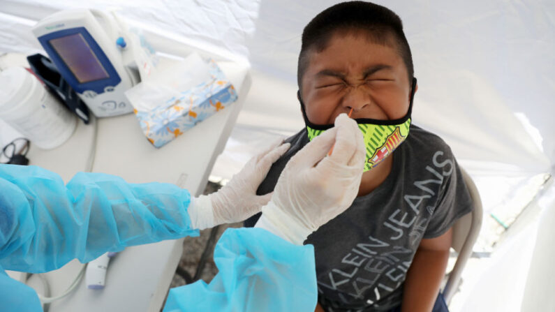 Un niño recibe una prueba gratuita de COVID-19 en una clínica móvil de St. John's Well Child & Family Center instalada fuera de la iglesia Walker Temple AME en el sur de Los Ángeles en medio de la pandemia de coronavirus en Los Ángeles, California, el 15 de julio de 2020. (Mario Tama/Getty Images)