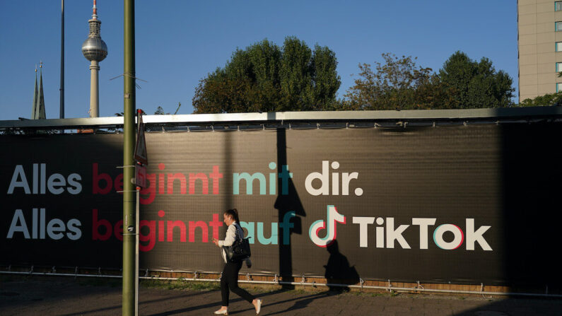 Una mujer joven con un teléfono inteligente pasa por delante de un anuncio de la empresa de redes sociales TikTok en Berlín, Alemania, el 21 de septiembre de 2020. (Sean Gallup/Getty Images)