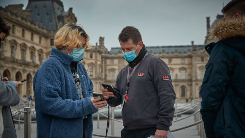 El personal del Museo del Louvre escanea los pases y certificados de vacunación de los visitantes, el 28 de enero de 2022 en París, Francia. (Kiran Ridley/Getty Images)