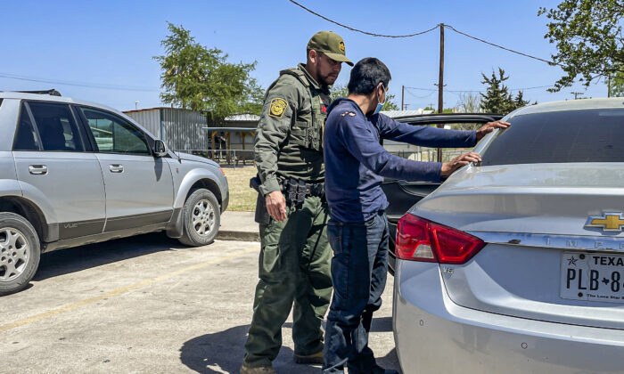Agentes de la Patrulla Fronteriza recogen a cuatro inmigrantes ilegales de México luego de que los agentes locales interceptaran su vehículo de tráfico ilegal, en Brackettville, Texas, el 8 de abril de 2022. (Charlotte Cuthbertson/The Epoch Times)