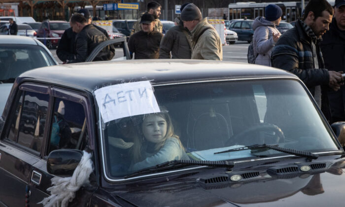 Una niña espera en un coche en un punto de evacuación en un convoy de coches y autobuses que transportan a cientos de personas evacuadas de Mariupol y Melitopol, en Zaporiyia, Ucrania, el 25 de marzo de 2022. (Chris McGrath/Getty Images)
