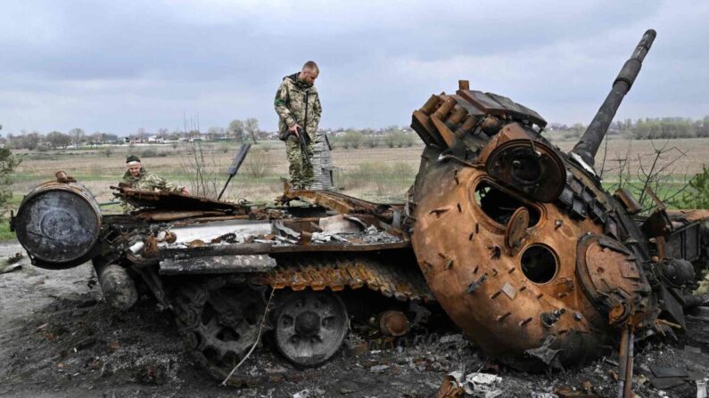 Militares ucranianos observan un tanque ruso destruido en una carretera en el pueblo de Rusaniv, cerca de Kiev, Ucrania, el 16 de abril de 2022. (Genya Savilov/AFP/Getty Images)
