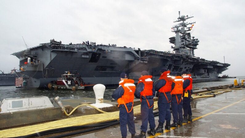 Los operarios de línea esperan para ayudar a atracar el portaaviones USS George Washington mientras los remolcadores trabajan para mover el gigante en su puerto de origen en Norfolk, Virginia, el 20 de diciembre de 2002. (Michael Sandberg/U.S. Navy/Getty Images)