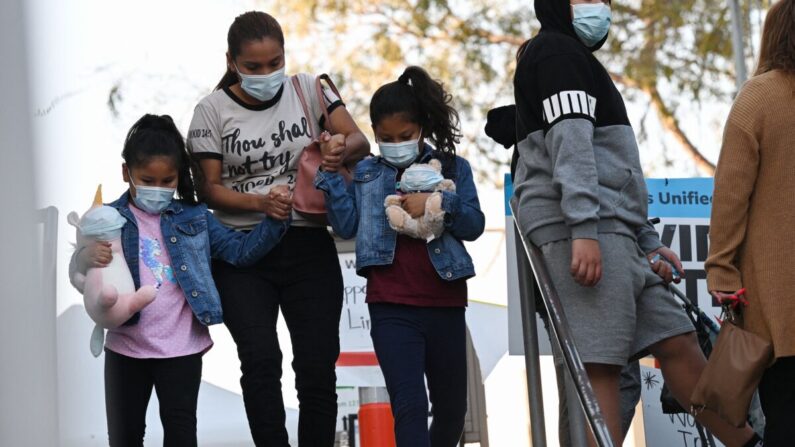 Una mujer y unas niñas salen de un centro de pruebas de COVID-19 en Los Ángeles, California, el 5 de enero de 2022. (Robyn Beck/AFP vía Getty Images)