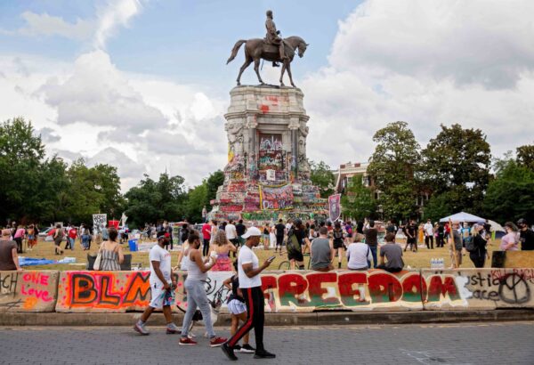 La gente se reúne alrededor de la estatua de Robert E. Lee en la avenida Monument en Richmond, Virginia, el 20 de junio de 2020. (Ryan M. Kelly/AFP vía Getty Images)