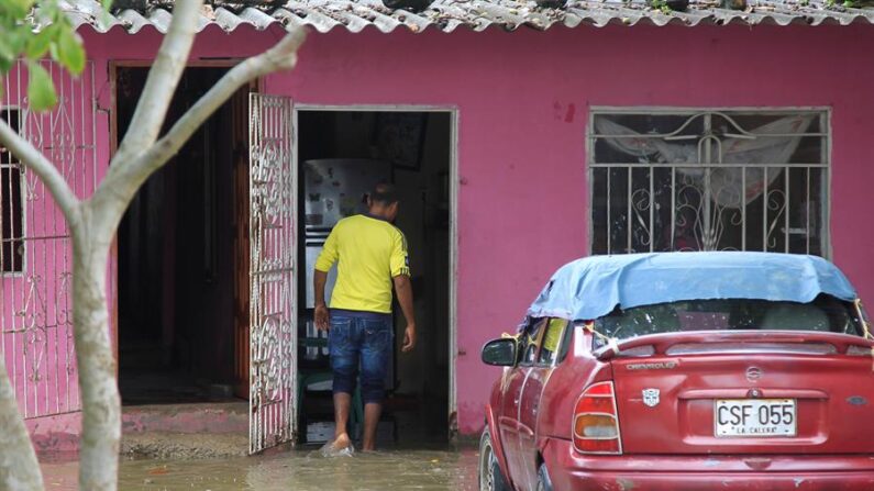 Un hombre entra a su casa inundada, en una fotografía de archivo. EFE/ Ricardo Maldonado Rozo
