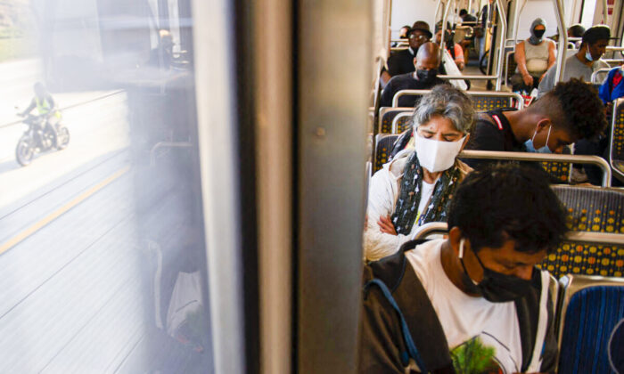 Los pasajeros del transporte público llevan mascarillas mientras viajan en un tren ligero en Los Ángeles, California, el 16 de julio de 2021. (Patrick T. Fallon/AFP vía Getty Images)