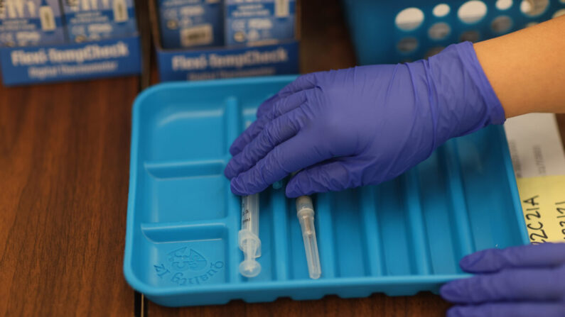 Un trabajador sanitario prepara las vacunas contra COVID-19 de Moderna en una clínica de Florida el 20 de mayo de 2021. (Joe Raedle/Getty Images)
