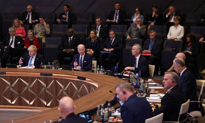 El primer ministro británico Boris Johnson (izq.) y el presidente Joe Biden (c.) escuchan mientras el secretario general de la OTAN, Jens Stoltenberg (c-d), se dirige a una reunión del Consejo del Atlántico Norte durante una cumbre extraordinaria en la sede de la OTAN en Bruselas el 24 de marzo de 2022. (Evelyn Hockstein/Pool/AFP vía Getty Images)