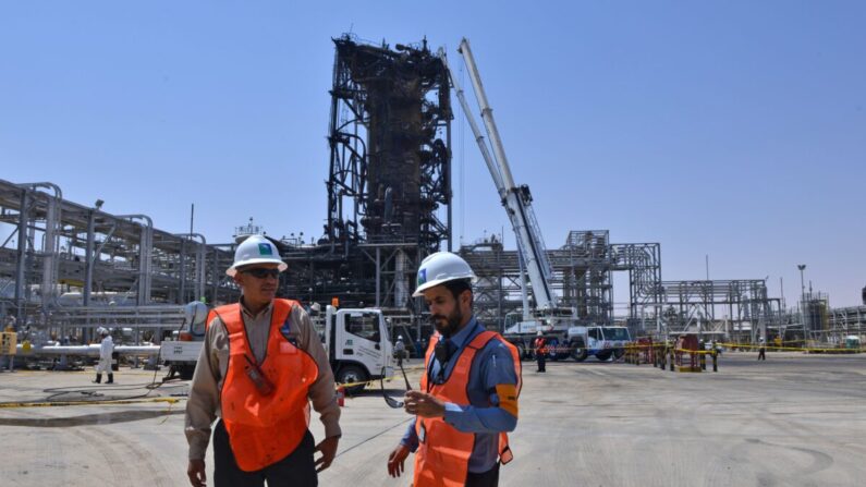 Empleados de la compañía petrolera Aramco permanecen cerca de una instalación muy dañada en la planta de procesamiento de petróleo de Khurais, en Arabia Saudí, el 20 de septiembre de 2019. (Fayez Nureldine/AFP vía Getty Images)
