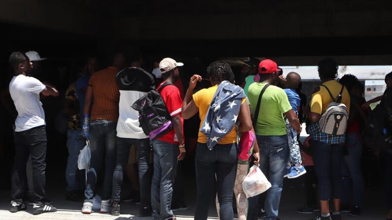 Un grupo de migrantes permanece en la entrada de un albergue, el 13 de mayo de 2022 en Matamoros, en el estado de Tamaulipas, México. (EFE/ Abraham Pineda-Jacome)