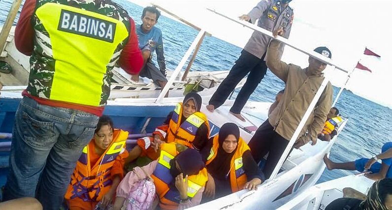 Una foto facilitada por la agencia nacional indonesia de búsqueda y rescate (BASARNAS) muestra a los supervivientes sentados en un barco de madera tras ser rescatados del agua frente a Takalar, Sulawesi del Sur, Indonesia, el 28 de mayo de 2022. EFE/EPA/Basarnas
