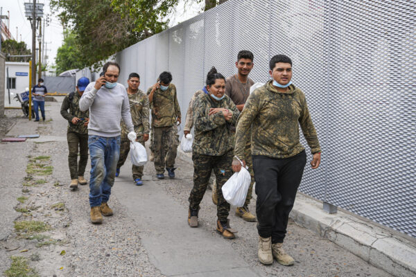 Un grupo de mexicanos camina de regreso a México después de haber sido regresados a la mitad del puente internacional desde Estados Unidos bajo el Título 42, en Piedras Negras, México, el 21 de abril de 2022. (Charlotte Cuthbertson/The Epoch Times)