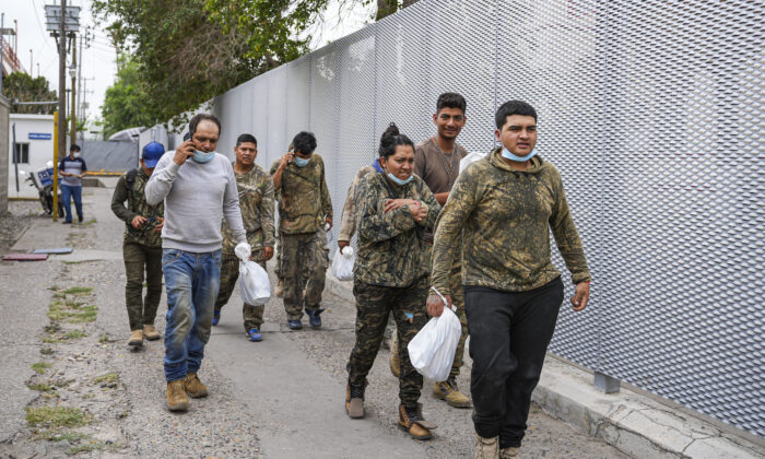 Un grupo de mexicanos camina de regreso a México después de ser devueltos a la mitad del puente internacional desde Estados Unidos bajo el Título 42, en Piedras Negras, México, el 21 de abril de 2022. (Charlotte Cuthbertson/The Epoch Times)
